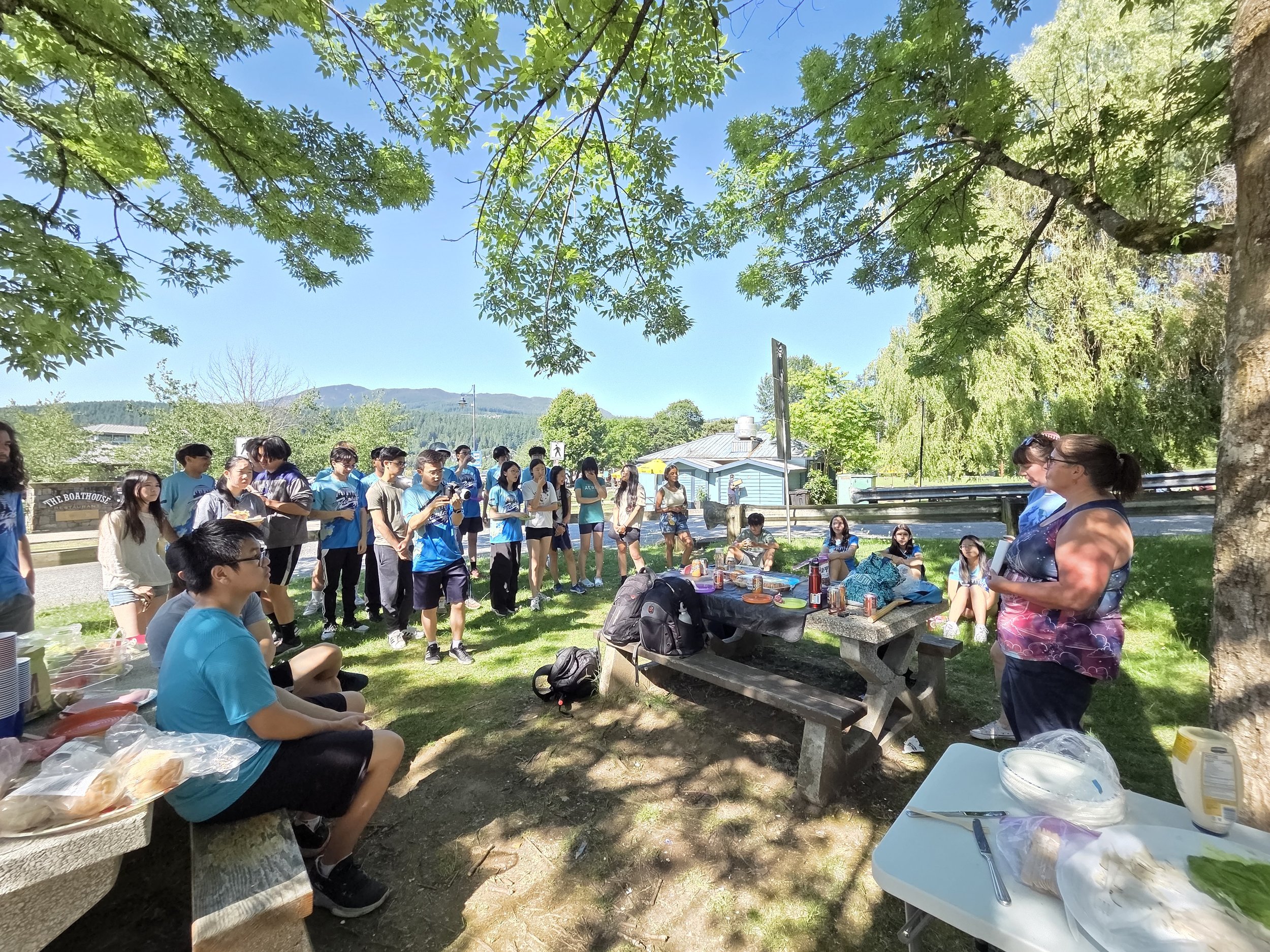 Students of Rapid Eagles high school dragon boat team listen attentively to their coaches at an end of season picnic at Rocky Point Park, Port Moody.
